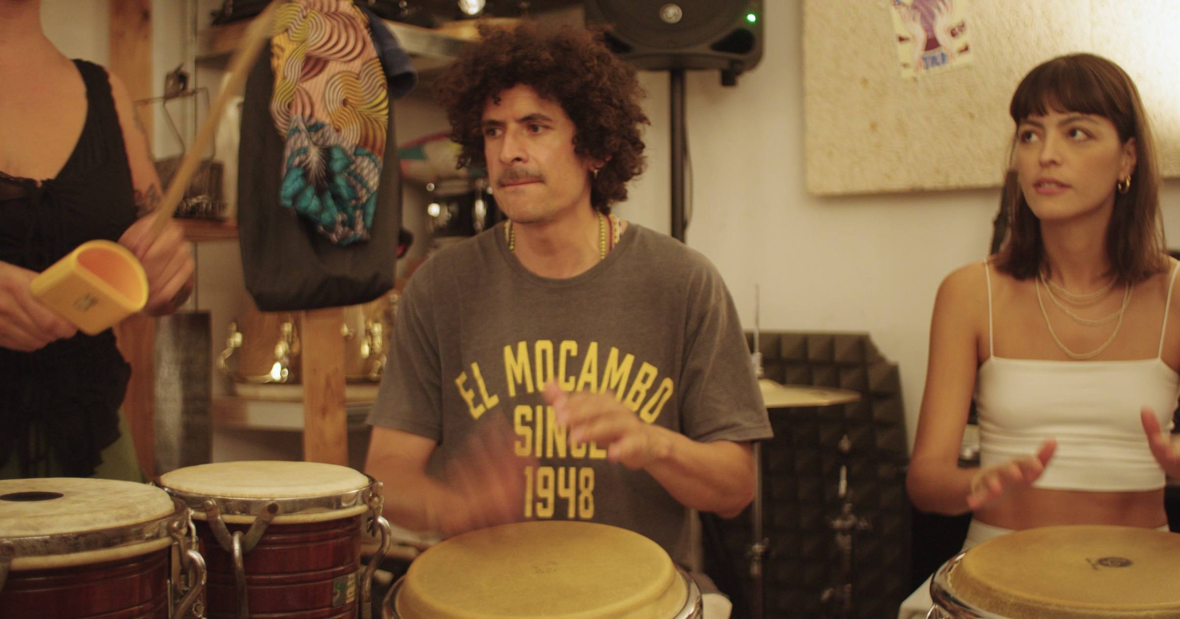 Alumnos tocando congas y shaker en una clase de percusión